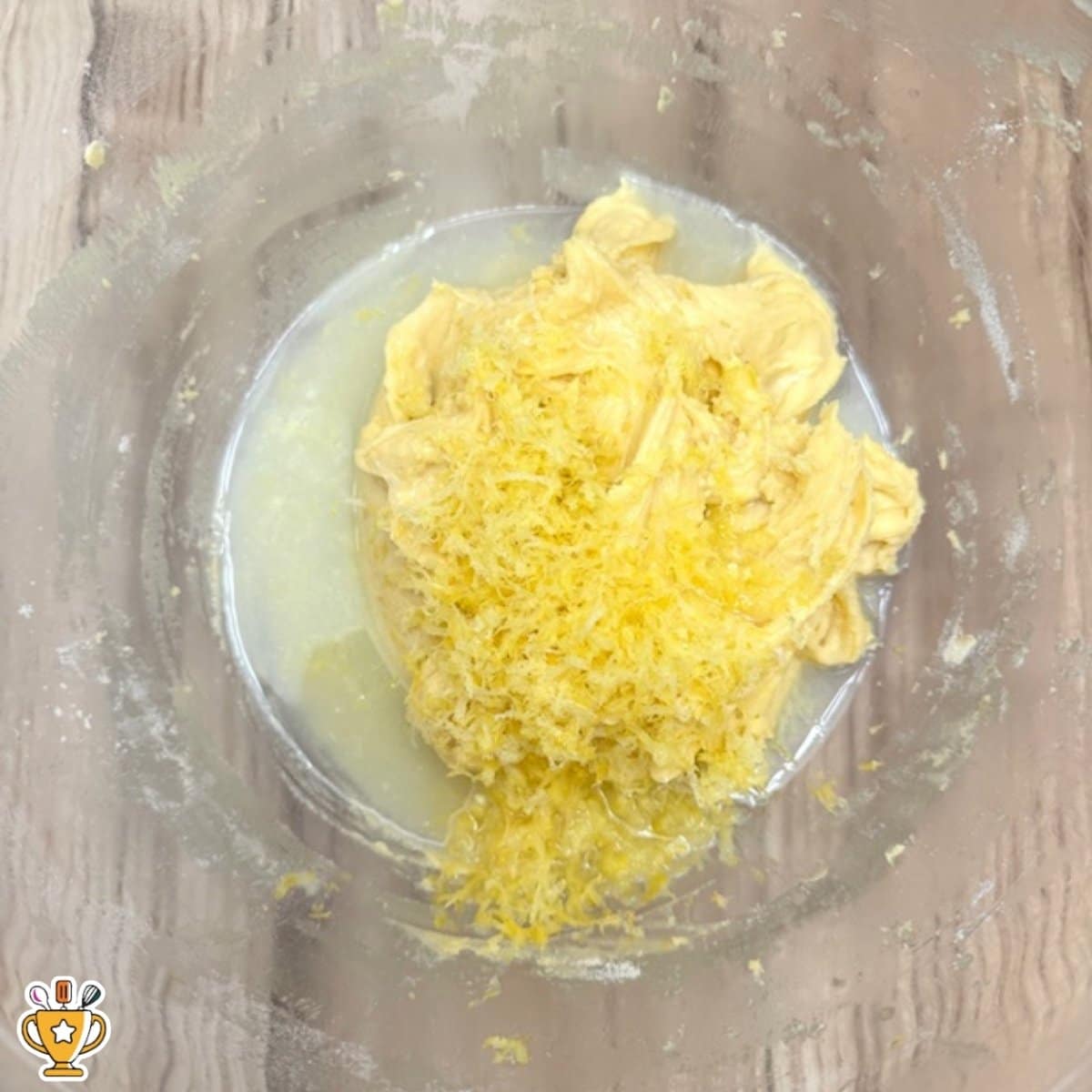 lemon custard cake batter with melted butter and fresh lemon zest in mixing bowl