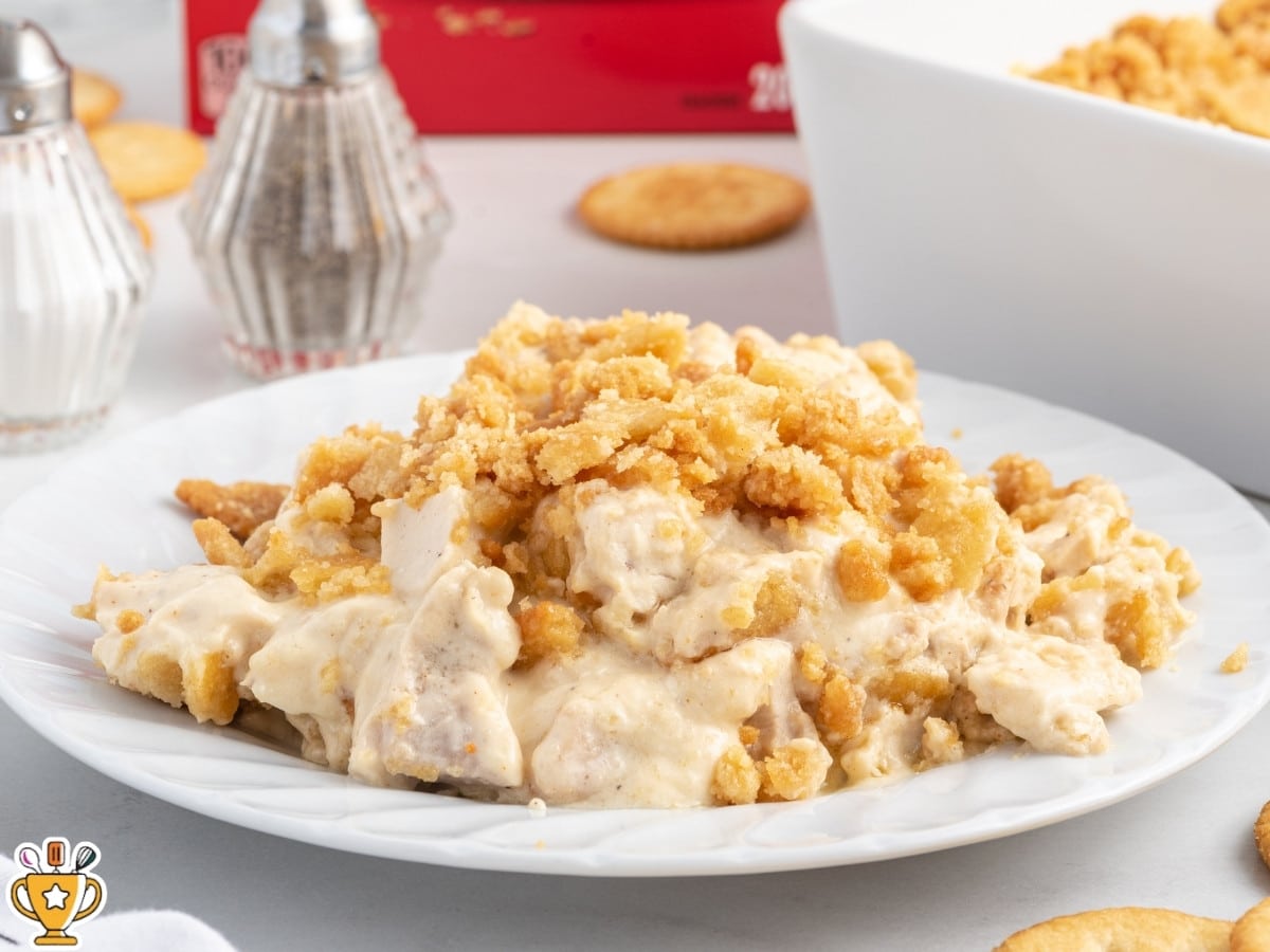 Serving of Ritz Cracker Chicken Casserole on a white plate, showing the creamy chicken filling topped with buttery golden Ritz cracker crumbs.