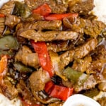 Pinterest image of Crock Pot Pepper Steak served over white rice with peppers and onions in savory sauce, featuring text that says “Pepper Steak in the crockpot!” and “hearty and flavorful!!”