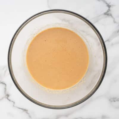Peanut butter, beef broth, eggs, and bacon grease whisked together in a glass bowl