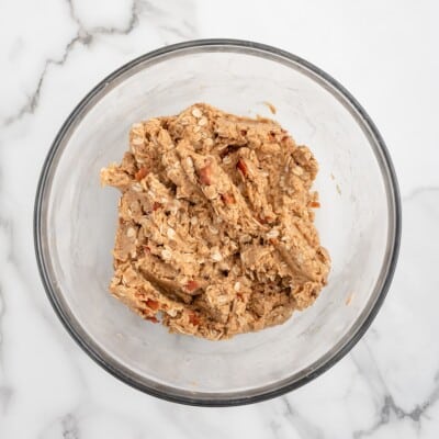 Bacon dog treat dough with crumbled bacon mixed in, in a glass bowl