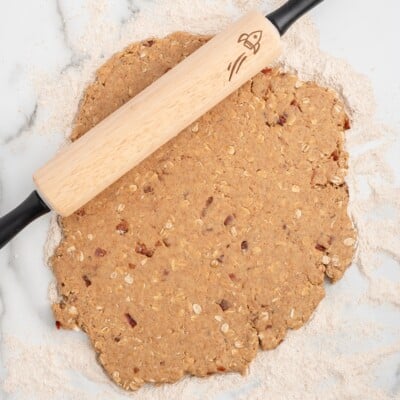 Bacon dog treat dough rolled out on a floured surface with a rolling pin