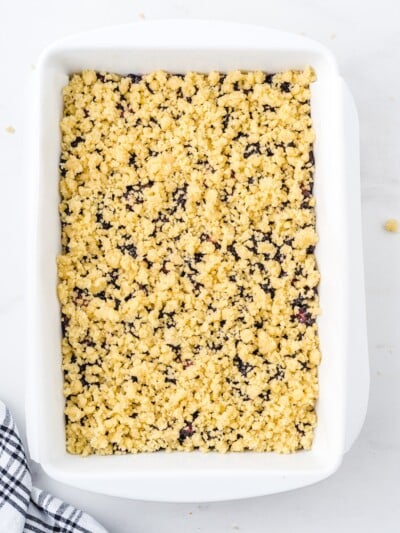 Blackberry pie bars with crumble topping scattered over the filling before baking