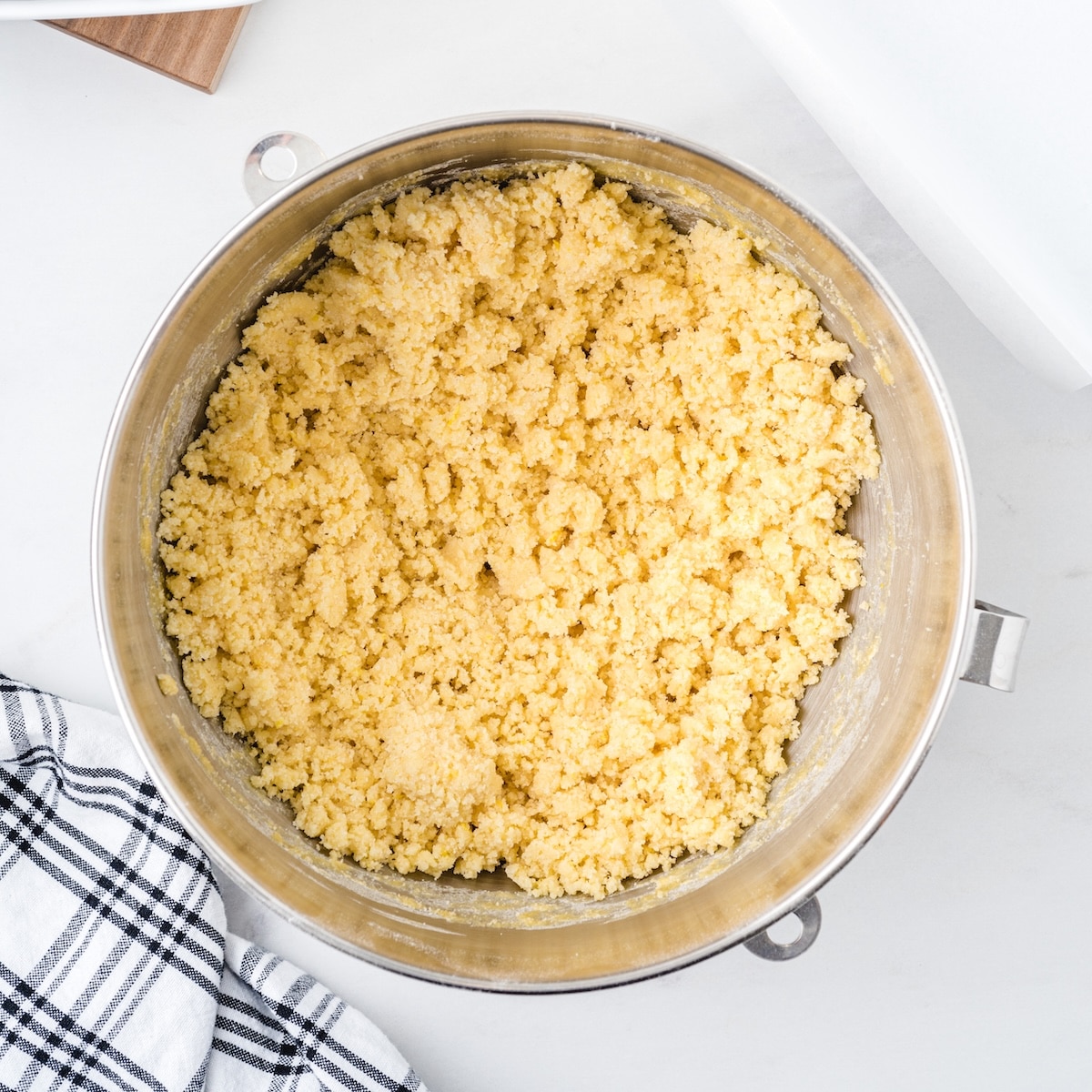 Crumbly lemon-zested pie bar dough in a stand mixer bowl