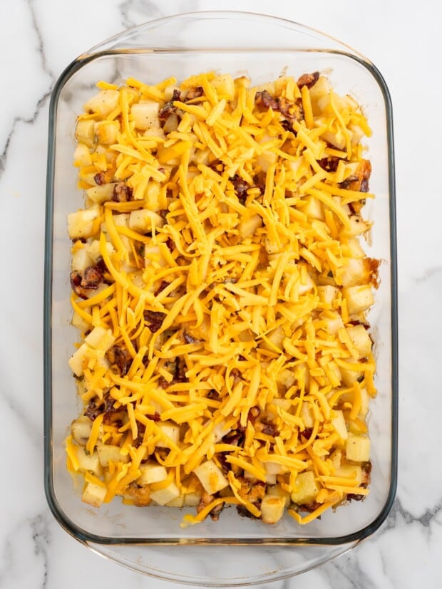 Shredded medium cheddar cheese scattered over the top of the partially baked Mississippi mud potatoes before returning the dish to the oven.