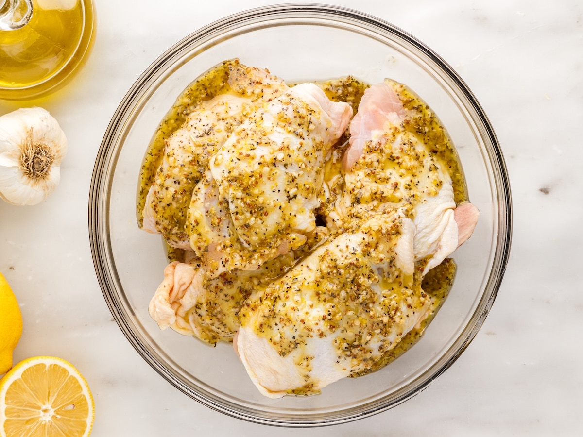 oven baked chicken thighs marinating in lemon Dijon sauce before baking