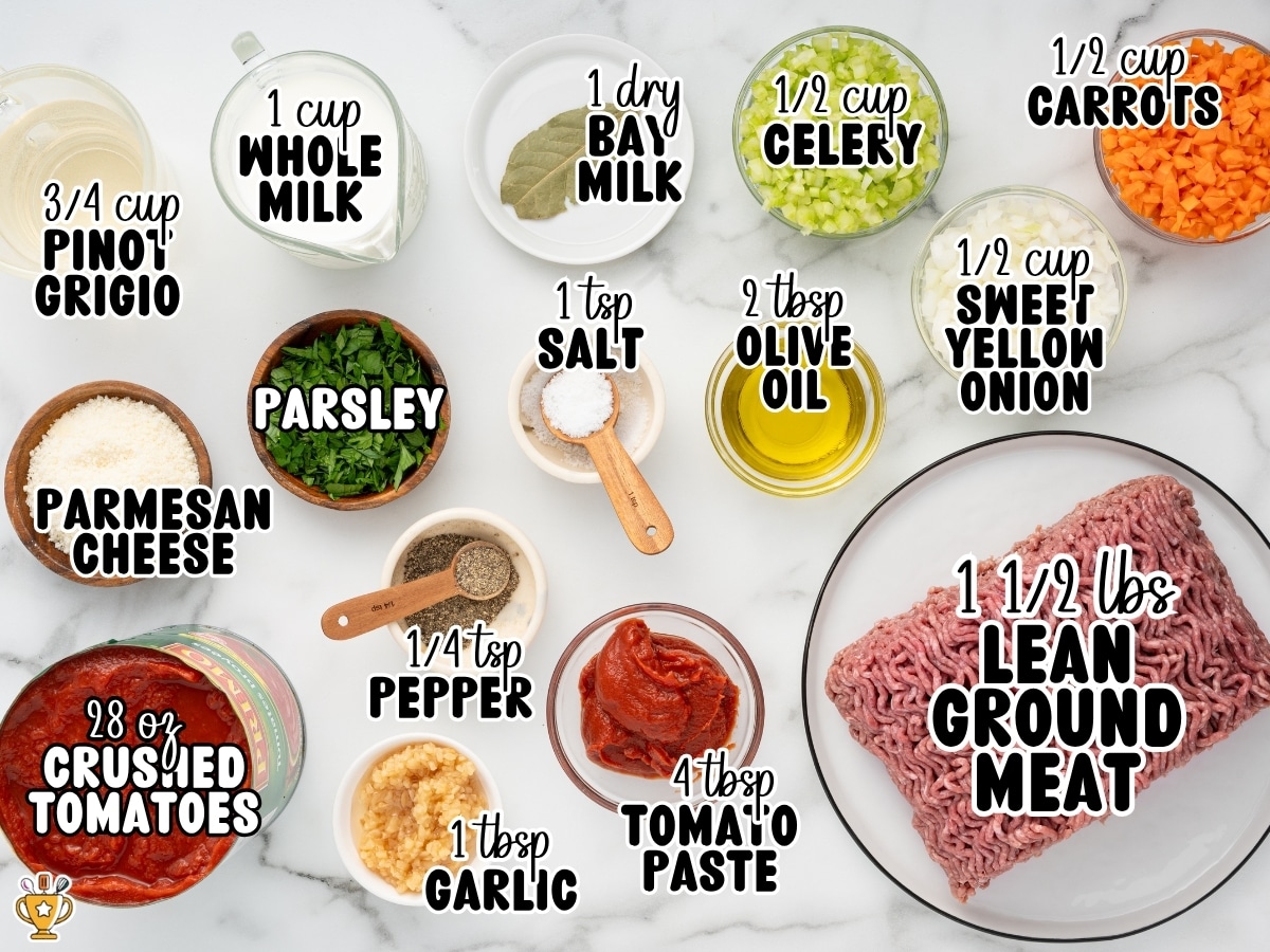 Ingredients for Bolognese arranged on a marble surface with text labels for ground meat, crushed tomatoes, tomato paste, Pinot Grigio, whole milk, carrots, celery, onion, garlic, olive oil, bay leaf, parsley, Parmesan cheese, salt, and pepper.