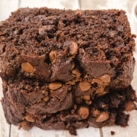 Close-up of stacked Chocolate Zucchini Bread slices showing a rich cocoa crumb and melted chocolate chips.