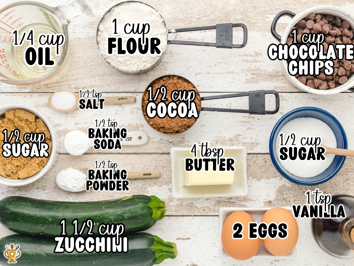 Overhead photo of the ingredients for Chocolate Zucchini Bread with labeled measurements including flour, cocoa powder, chocolate chips, zucchini, eggs, butter, oil, sugars, baking powder, baking soda, salt, and vanilla.