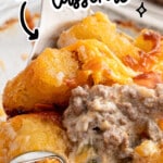 Pinterest graphic for Hamburger Tater Tot Casserole featuring a close-up of the creamy casserole with crispy tater tots, melted cheddar cheese, ground beef, and green beans. Text reads "Hamburger Tater Tot Casserole" and "so cheesy!!" with an inset image of the full baked casserole and the Best Blog Recipes logo.