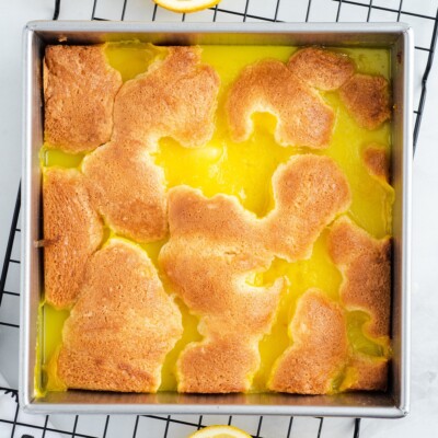 Freshly baked Lemon Cobbler cooling in a square baking pan, featuring a golden brown cobbler topping over a bright, creamy lemon filling.