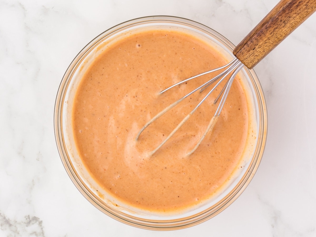 Red Robin copycat campfire sauce stirred with a whisk in a glass bowl