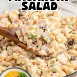 Pinterest pin for Easy Chicken Macaroni Salad showing a wooden spoon scooping creamy macaroni salad filled with chicken, pineapple, celery, carrots, raisins, red onion, and cheddar cheese. Text on image reads “Easy Chicken Macaroni Salad” and “Ready in Just 40 Mins!”