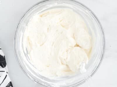 Cream cheese mixture beaten smooth in a glass bowl with a hand mixer