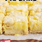 Easy lemon pie bars with a crumbly cake mix crust and lemon curd filling on a wooden cutting board, with a box of vanilla cake mix and a jar of lemon curd shown below.