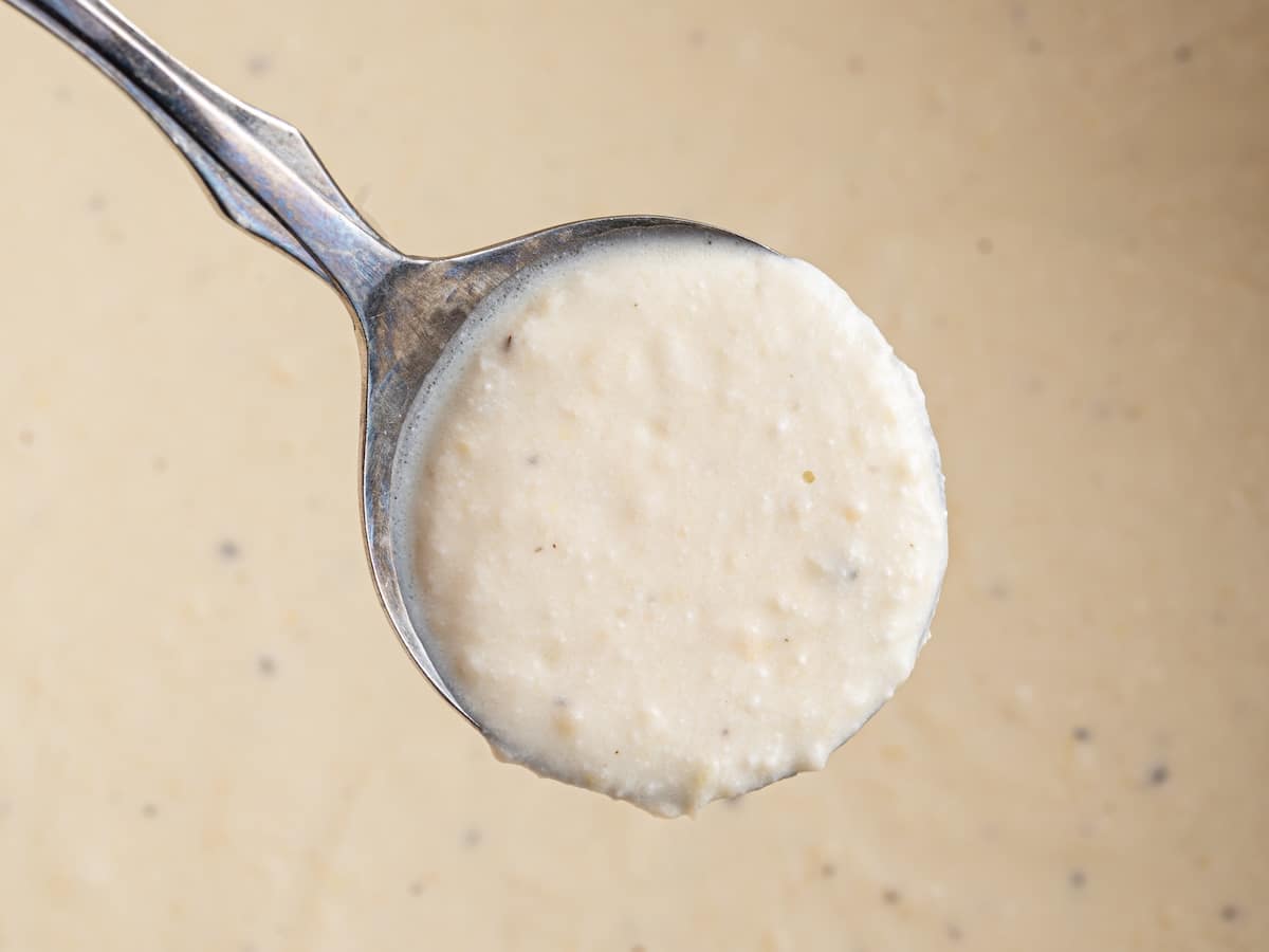 Lemon ricotta pasta sauce on a spoon, showing the creamy texture before tossing with spaghetti