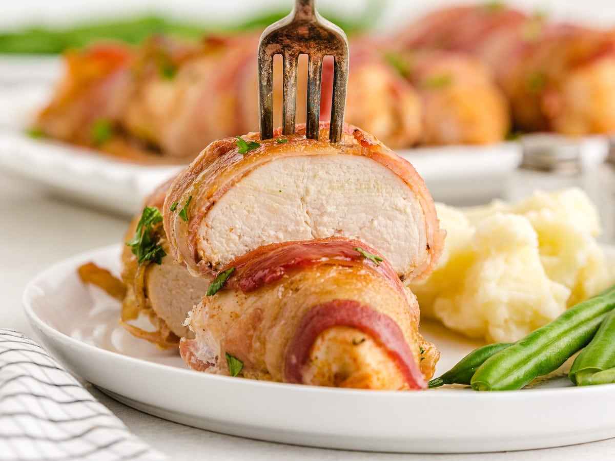 Sliced Bacon Wrapped Chicken showing juicy, tender chicken breast inside crispy golden bacon, served with creamy mashed potatoes and fresh green beans for an easy weeknight dinner.