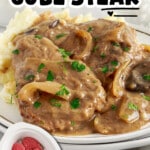 Vertical Pinterest graphic featuring Crock Pot Cube Steak covered in rich mushroom and onion gravy with mashed potatoes. Text reads “Crock Pot Cube Steak” and “Just Set It & Forget It.”