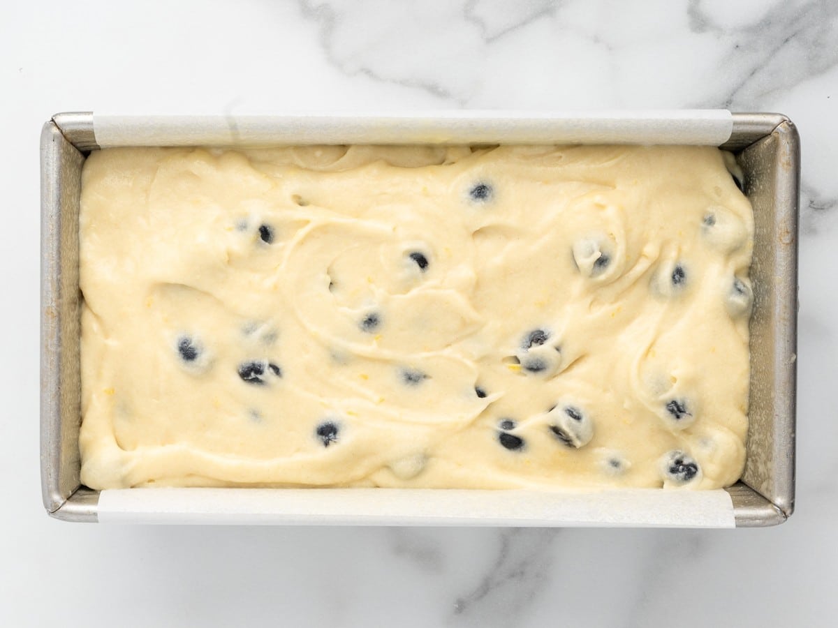Smooth, creamy Lemon Blueberry Pound Cake batter mixed until light and fluffy in a glass bowl before fresh blueberries are folded in.