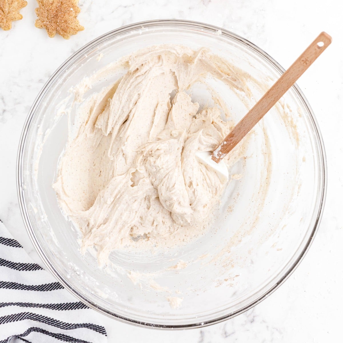 Overhead view of smooth cinnamon cream cheese dip mixed in a glass bowl with a spatula while preparing Pie Crust Chips with Cinnamon Dip.