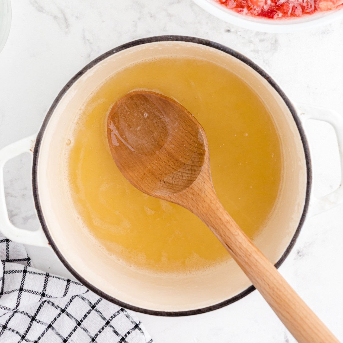 Fruit pectin dissolved in water and heated in a saucepan before being added to the strawberries to make homemade Strawberry Freezer Jam.