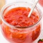 Glass mason jar filled with homemade Strawberry Freezer Jam made with fresh strawberry pieces, showing the finished bright red jam ready to refrigerate or freeze.