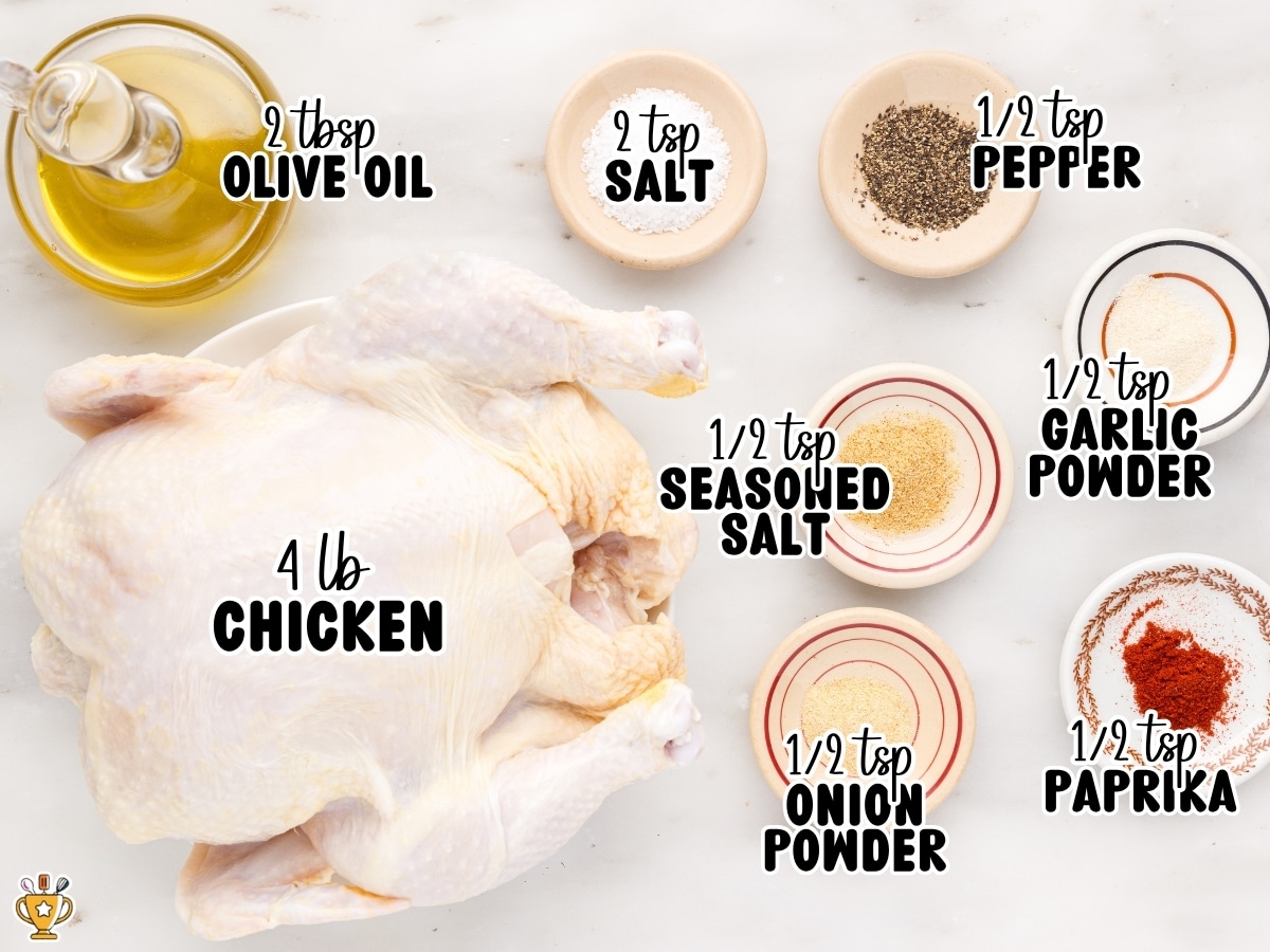 Overhead ingredient layout for Air Fryer Whole Chicken showing a 4-pound whole chicken with 2 tablespoons olive oil, 2 teaspoons salt, ½ teaspoon pepper, ½ teaspoon seasoned salt, ½ teaspoon garlic powder, ½ teaspoon onion powder, and ½ teaspoon paprika.